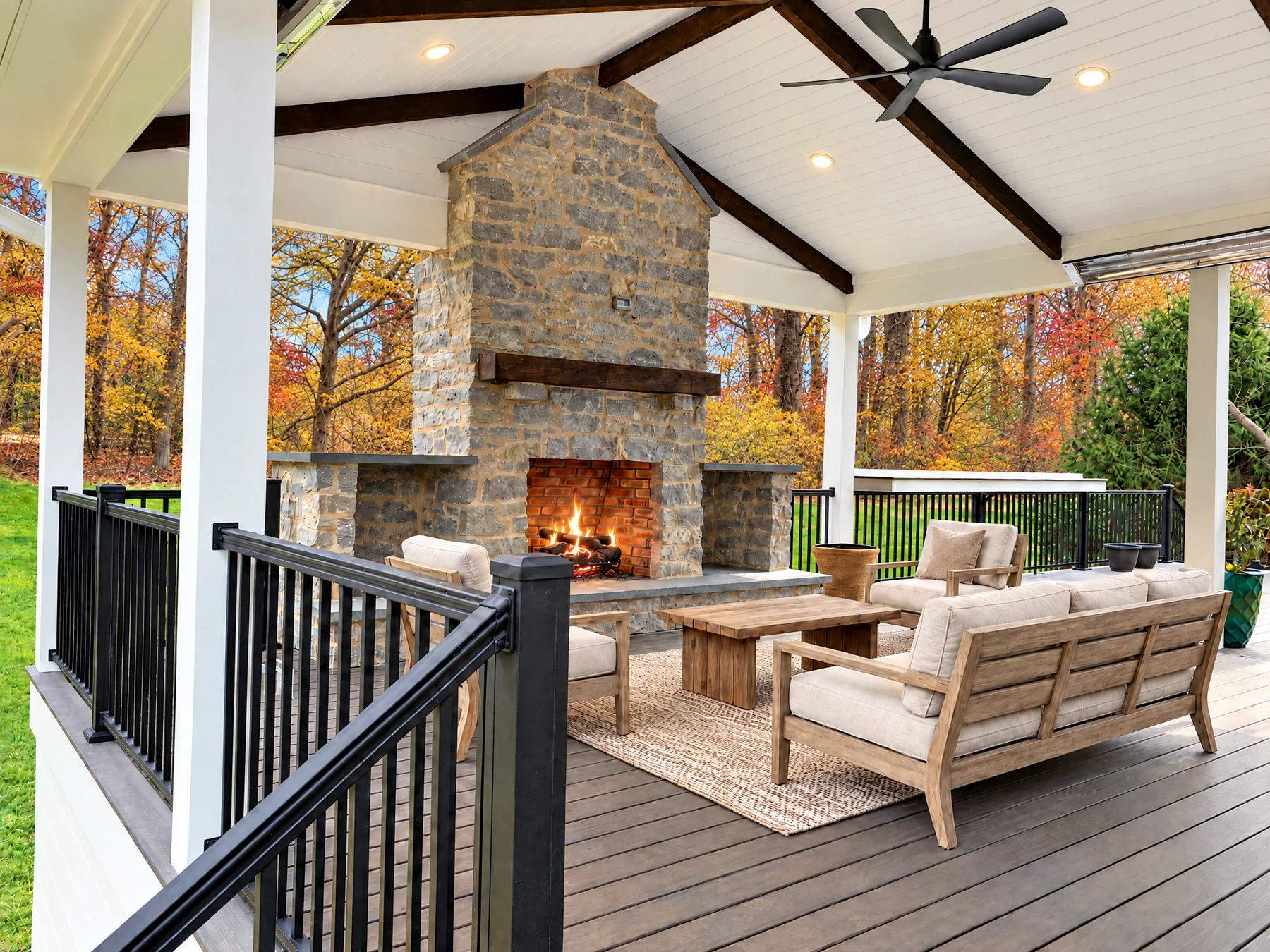 Covered outdoor living space with stone fireplace and composite decking built by Buck Run Builders