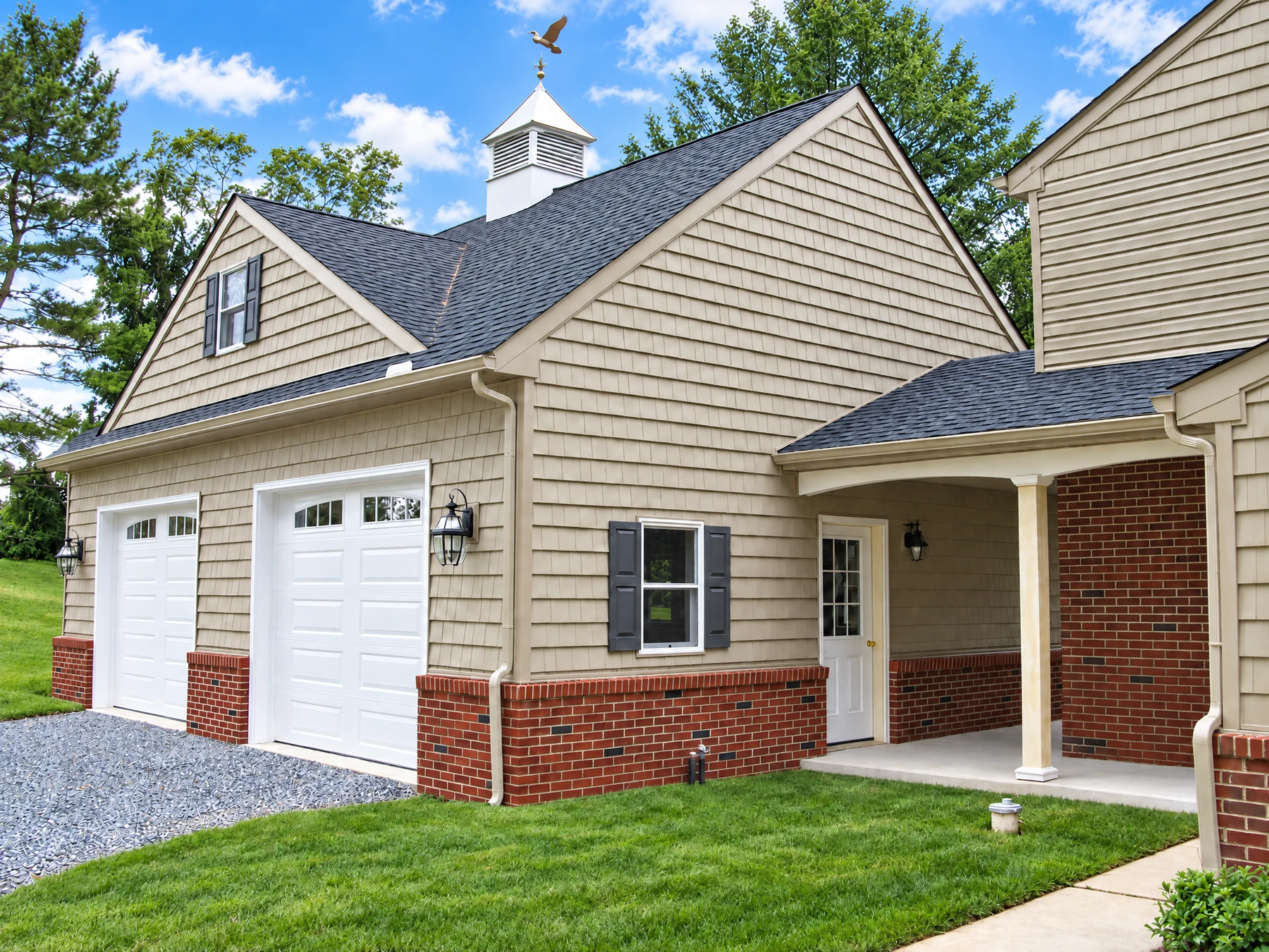 Attached garage with coordinated rooflines, siding, and brick detailing by Buck Run Builders